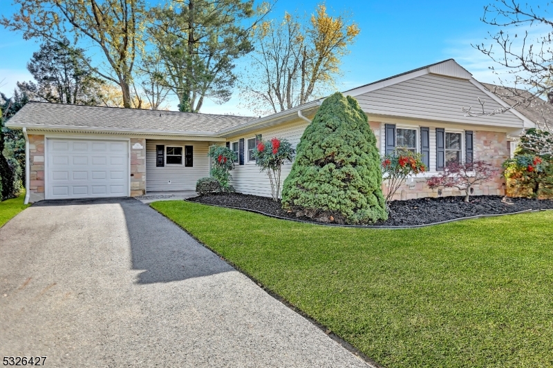 front view of a house with a yard and potted plants