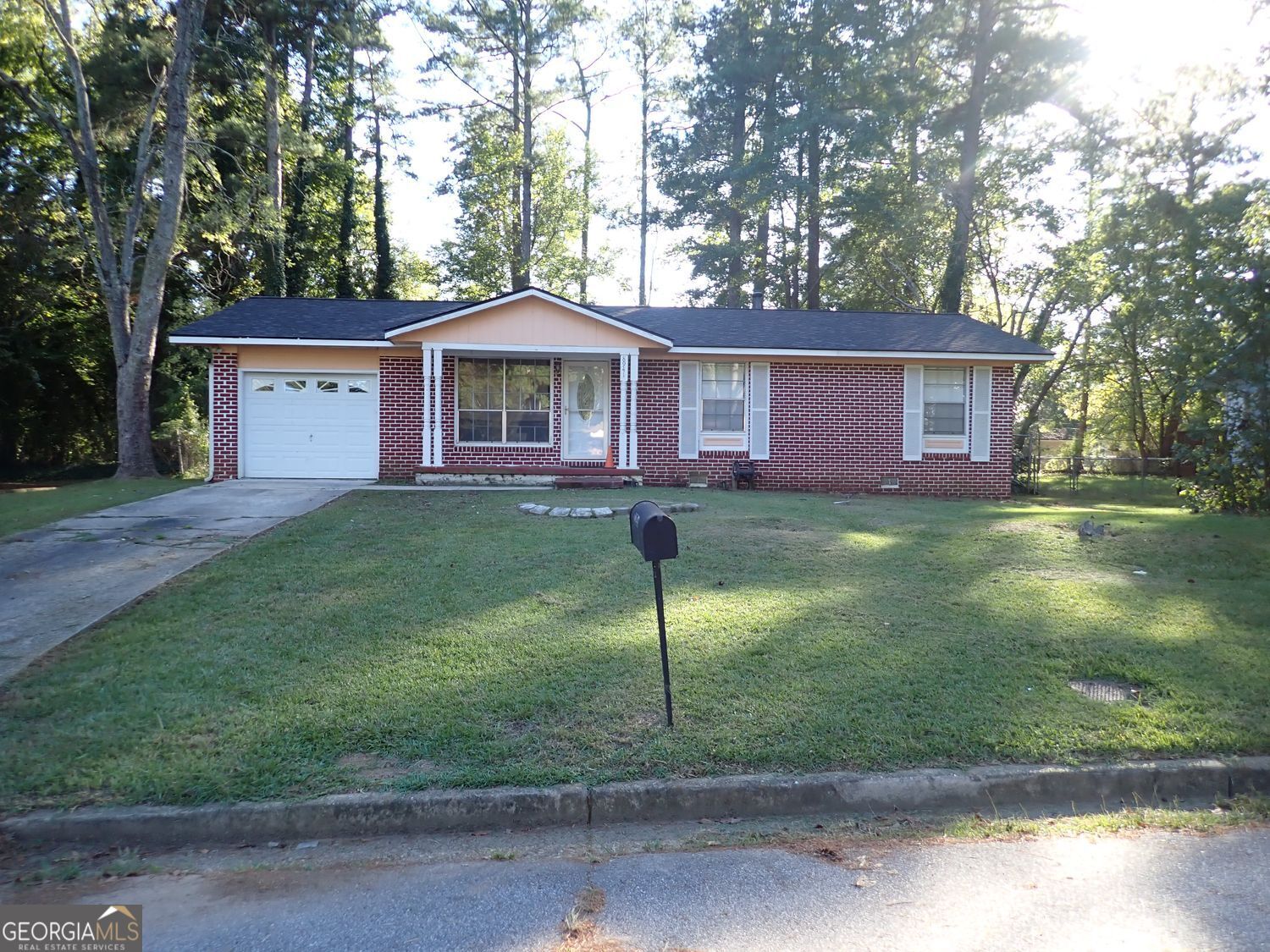 a view of a house with a yard and large tree