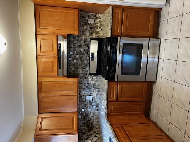 a kitchen with granite countertop a stove top oven microwave and cabinets