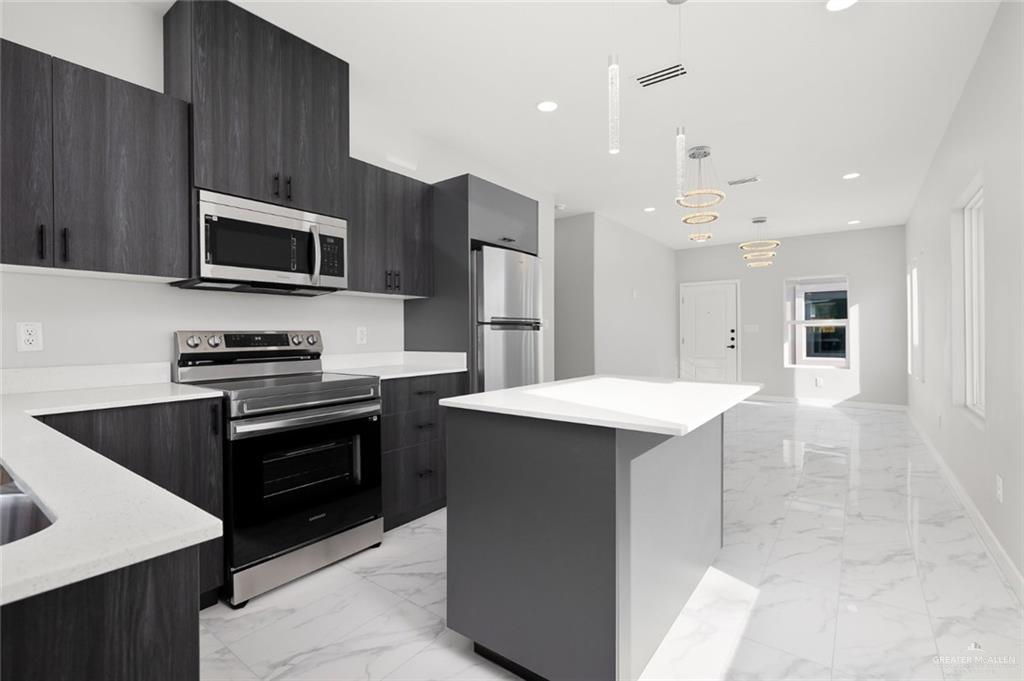 a kitchen with a sink a microwave a stove and refrigerator