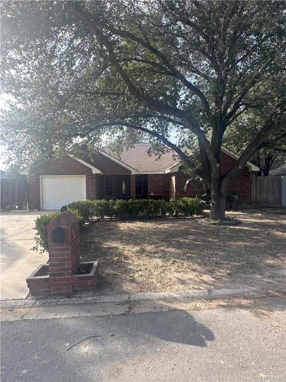 a front view of house with yard and trees around