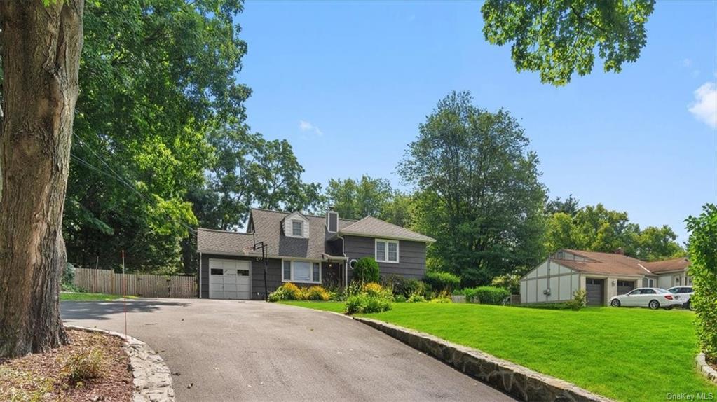 a front view of a house with a yard and trees