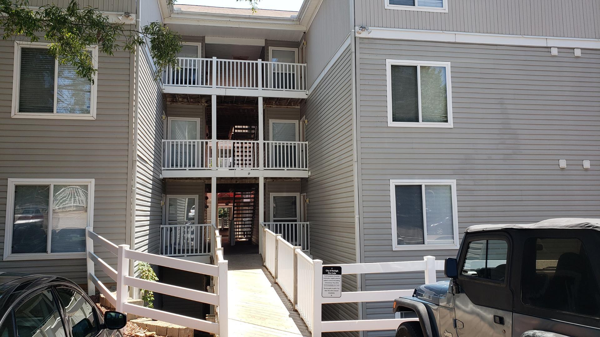 a view of residential house with deck and furniture