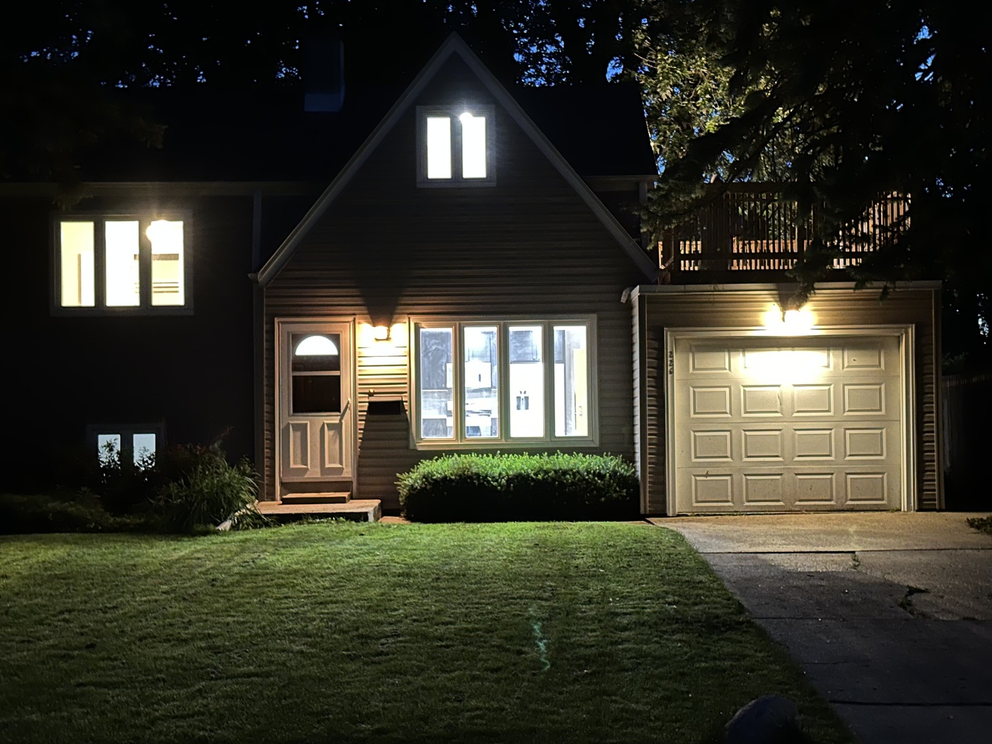 a view of a porch in front of a house with a large tree