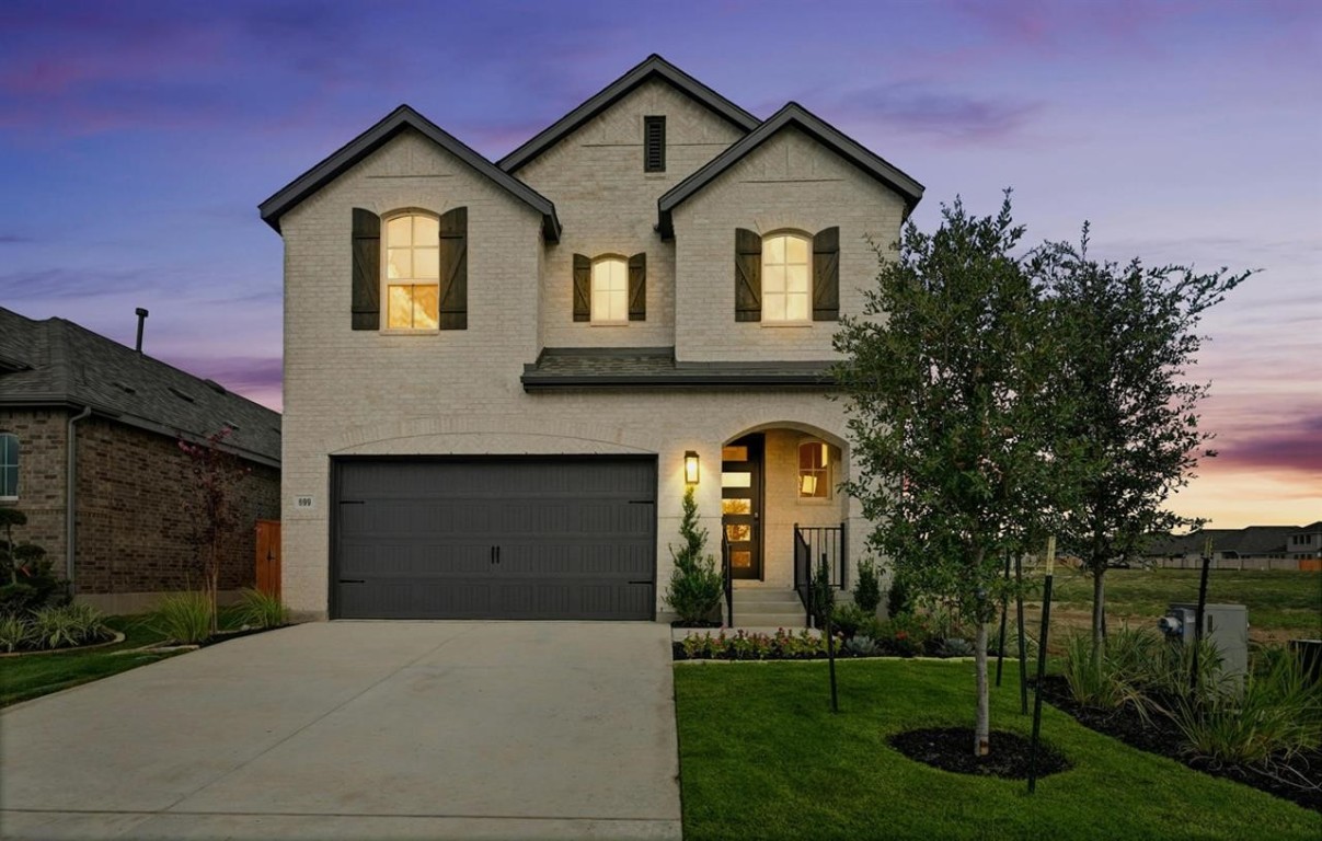 a front view of a house with a yard and garage