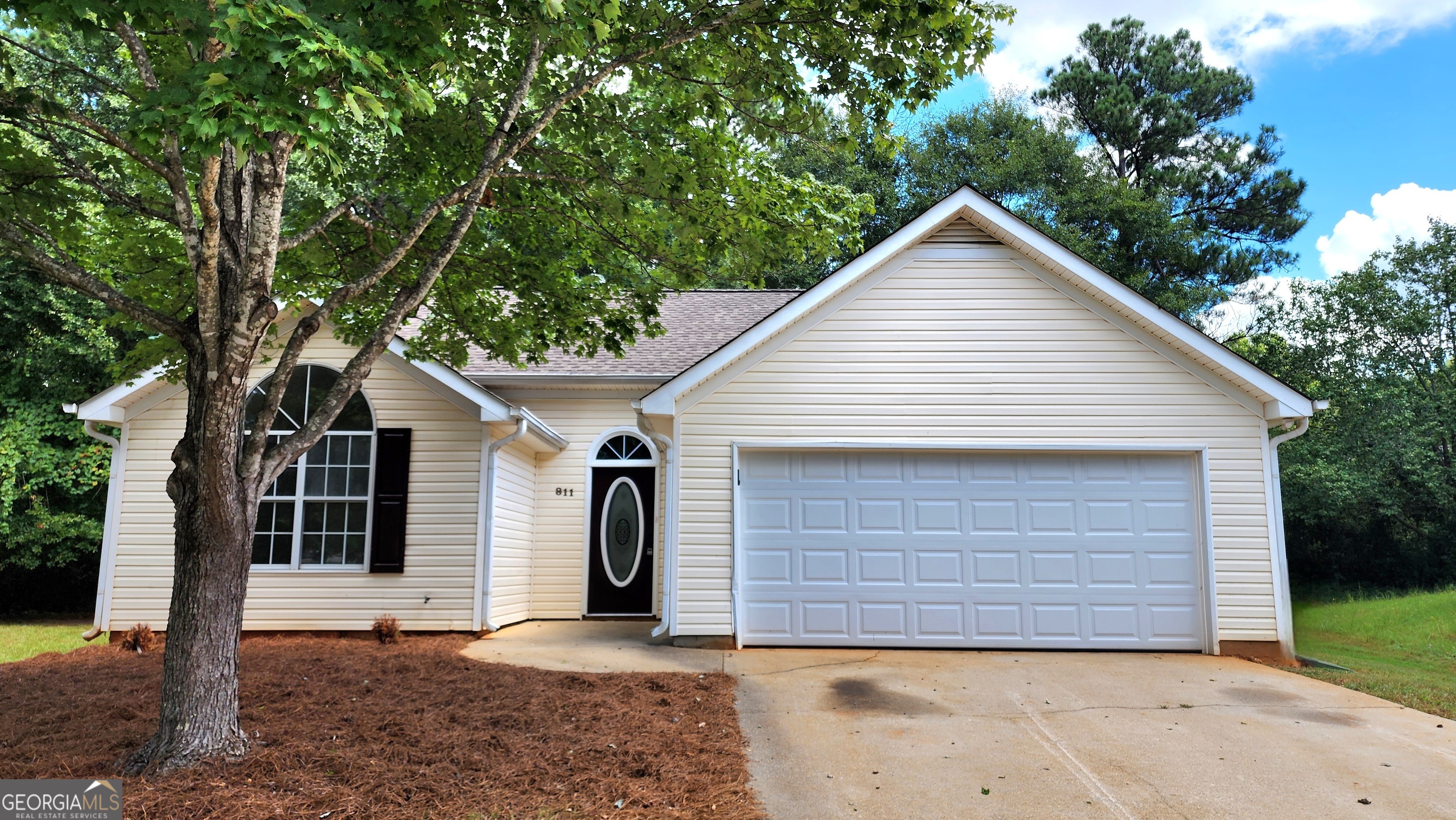 a view of house with a tree and yard