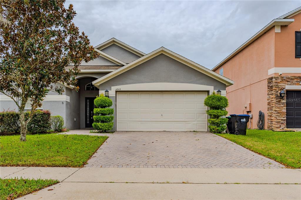 a front view of house with yard and garage