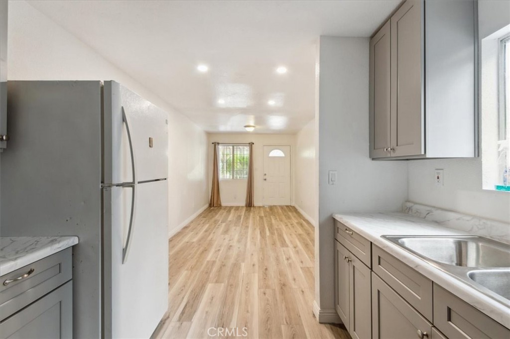 a view of a kitchen with white cabinets and wooden floor