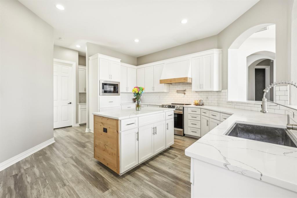 a kitchen with white cabinets and white appliances