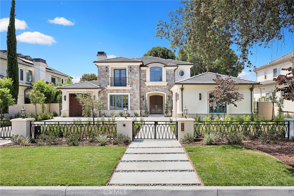 a front view of a house with a garden and plants