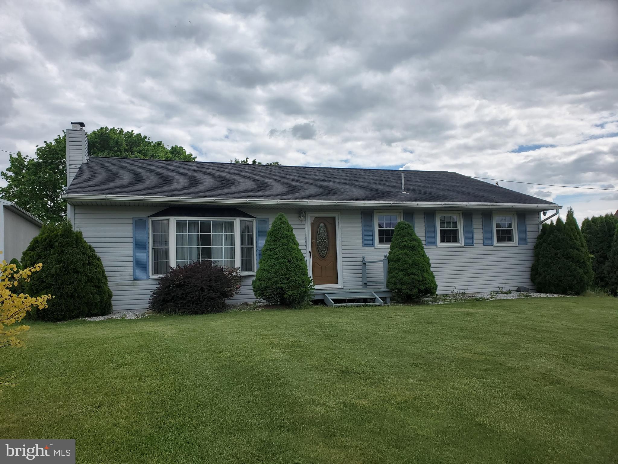 a front view of a house with a garden and yard