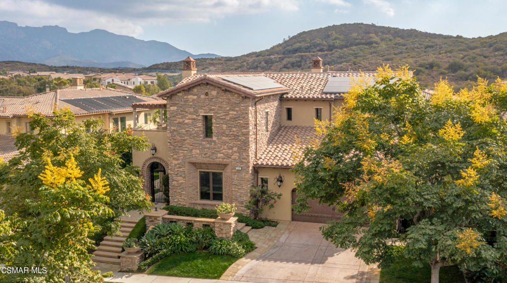 a front view of a house with a yard and mountain