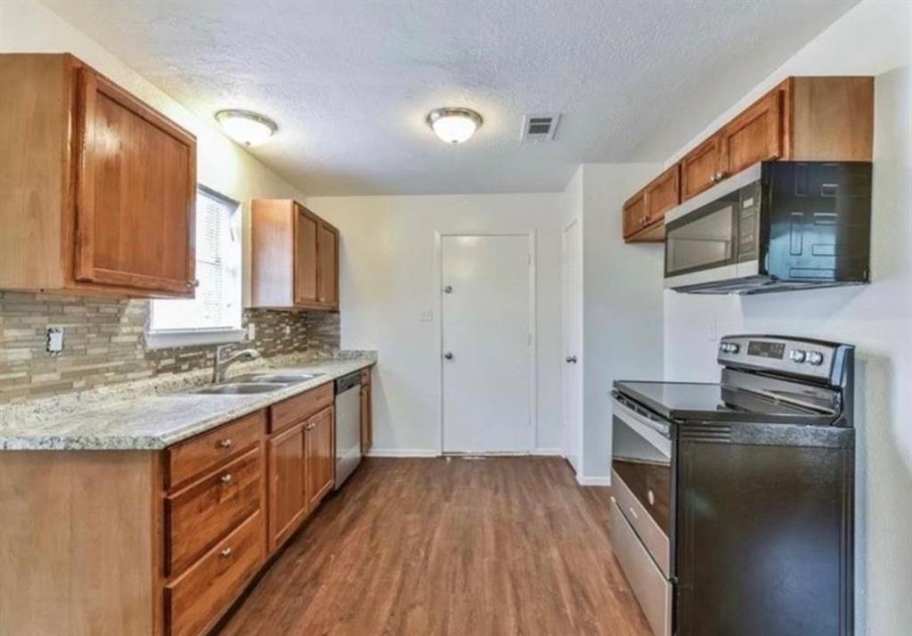 a kitchen with stainless steel appliances granite countertop a stove and a sink