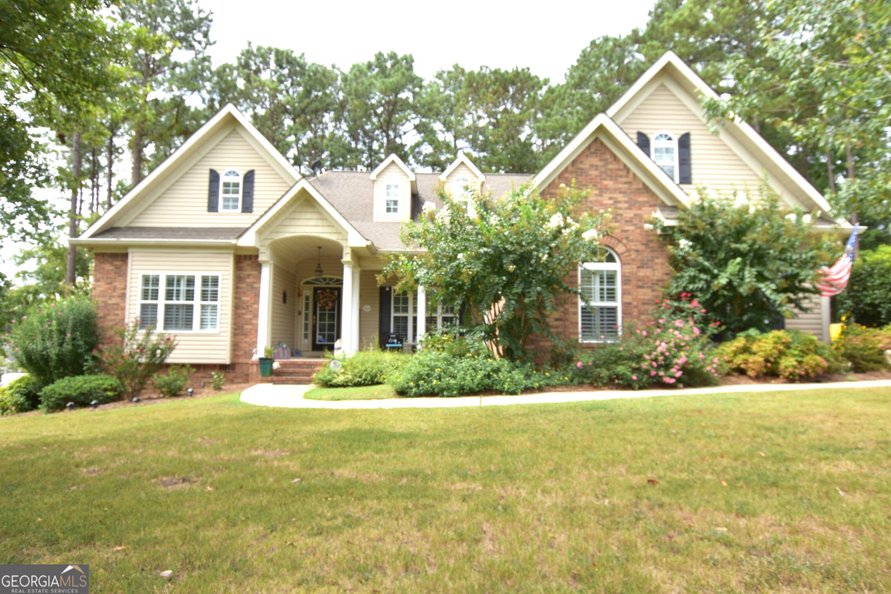 a front view of a house with a yard and trees