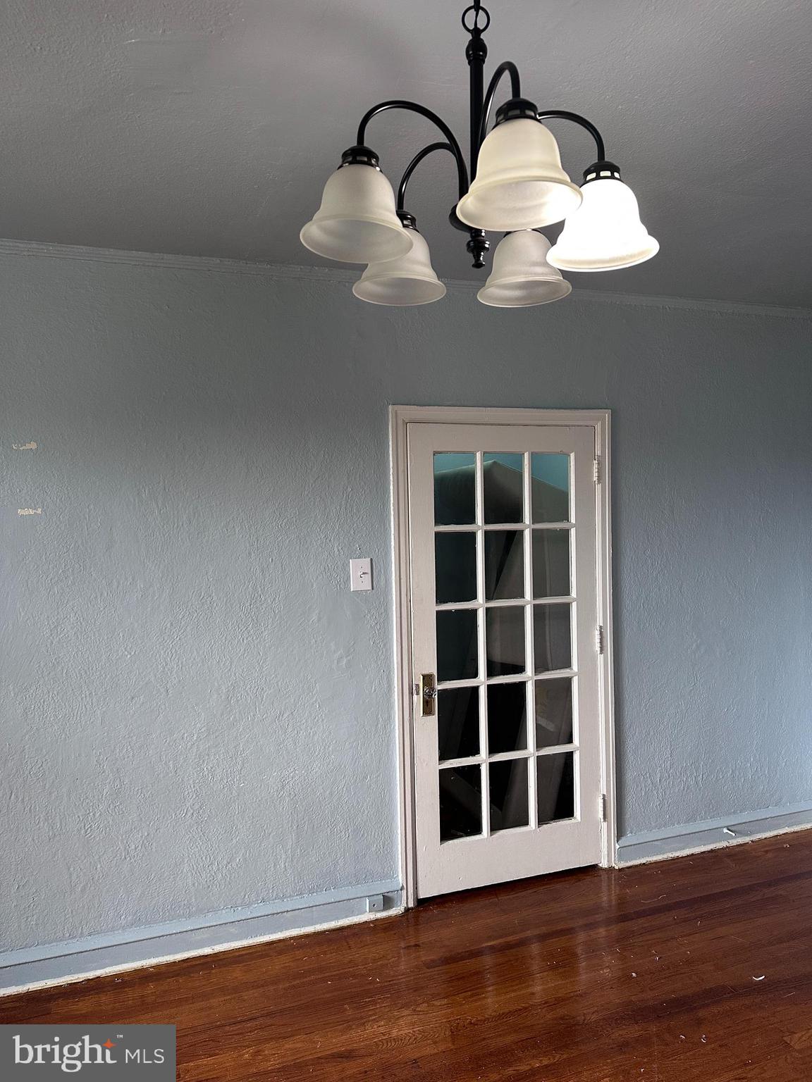 a view of a room with wooden floor and chandelier