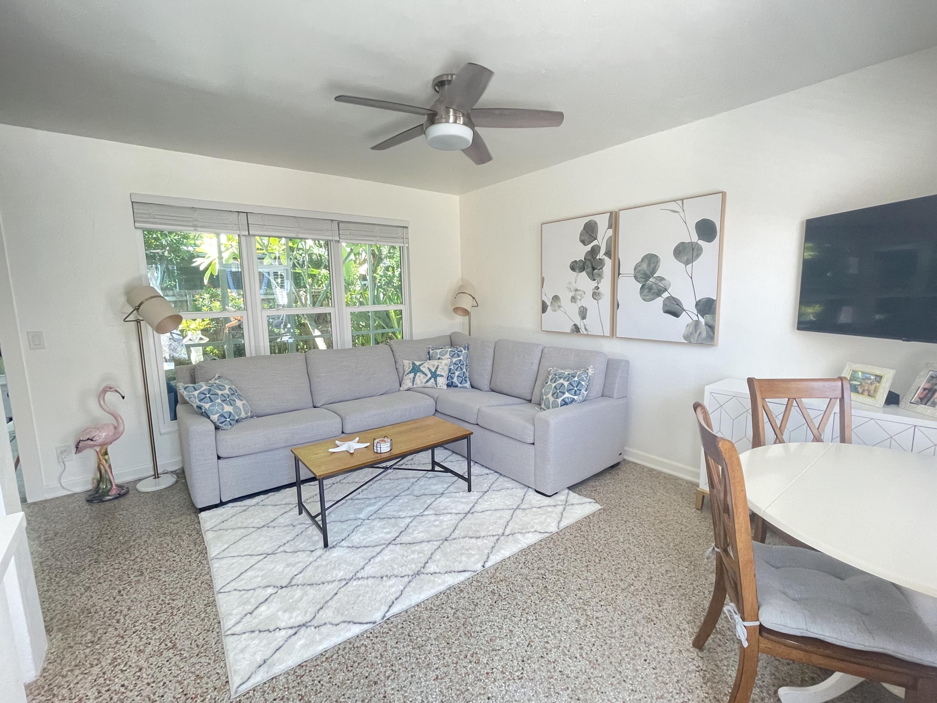 a living room with furniture a flat screen tv and a large window