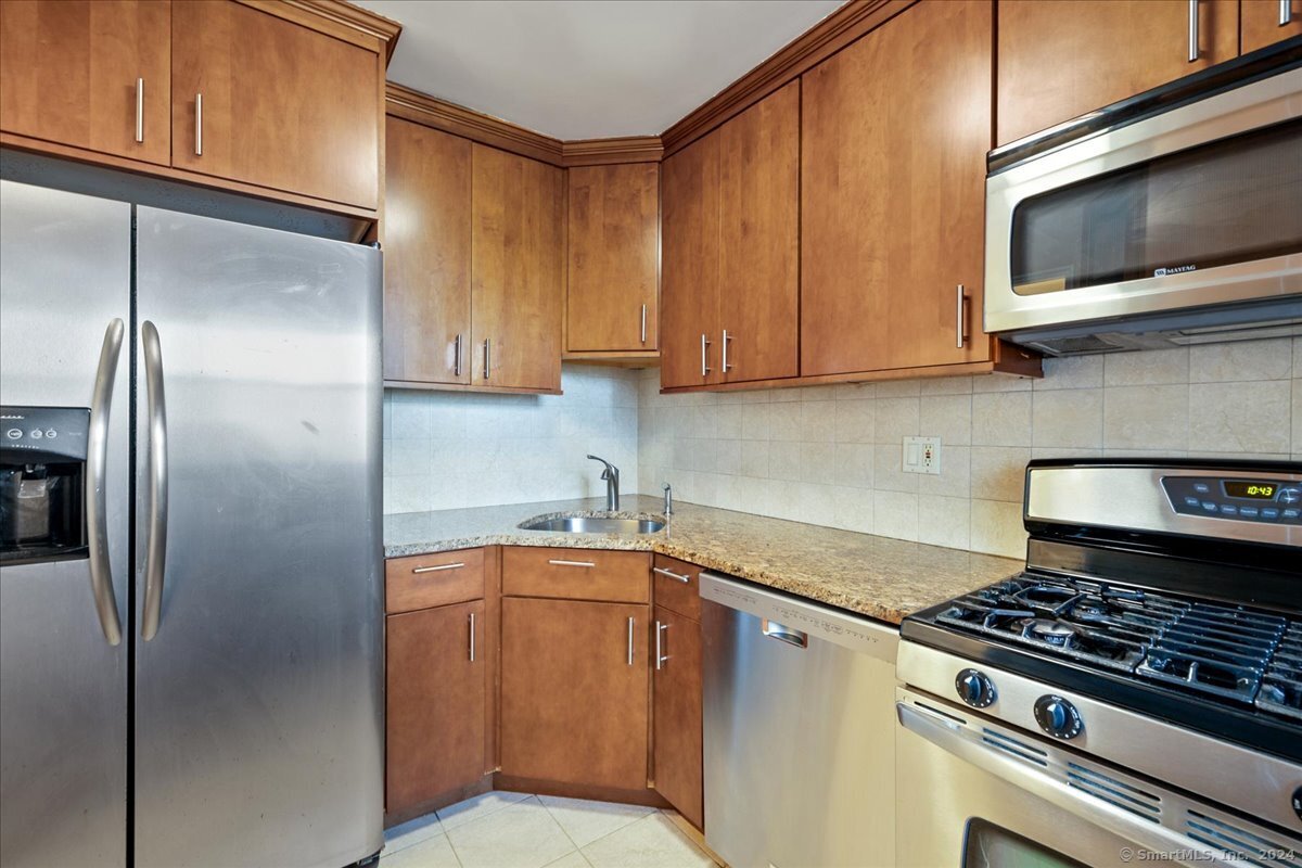 a kitchen with stainless steel appliances granite countertop a refrigerator stove and microwave