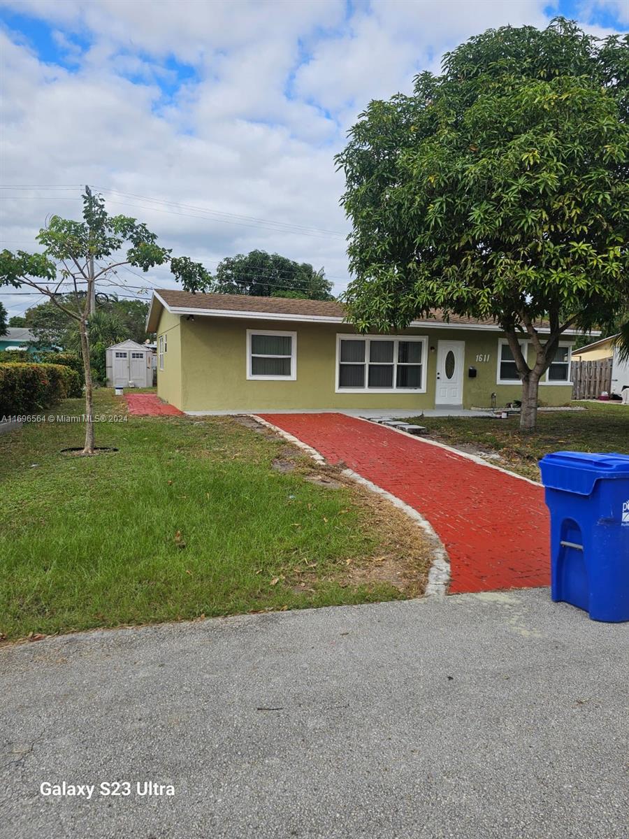 front view of house with a yard and trees