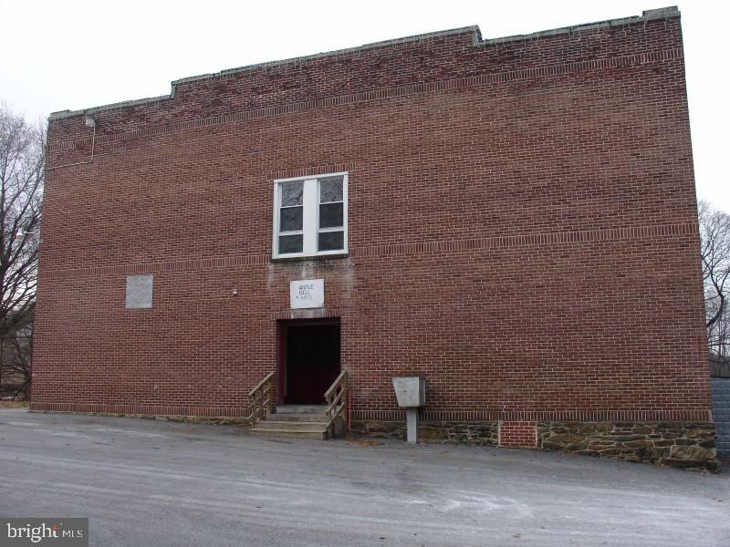 a tall brick building with a bench in it