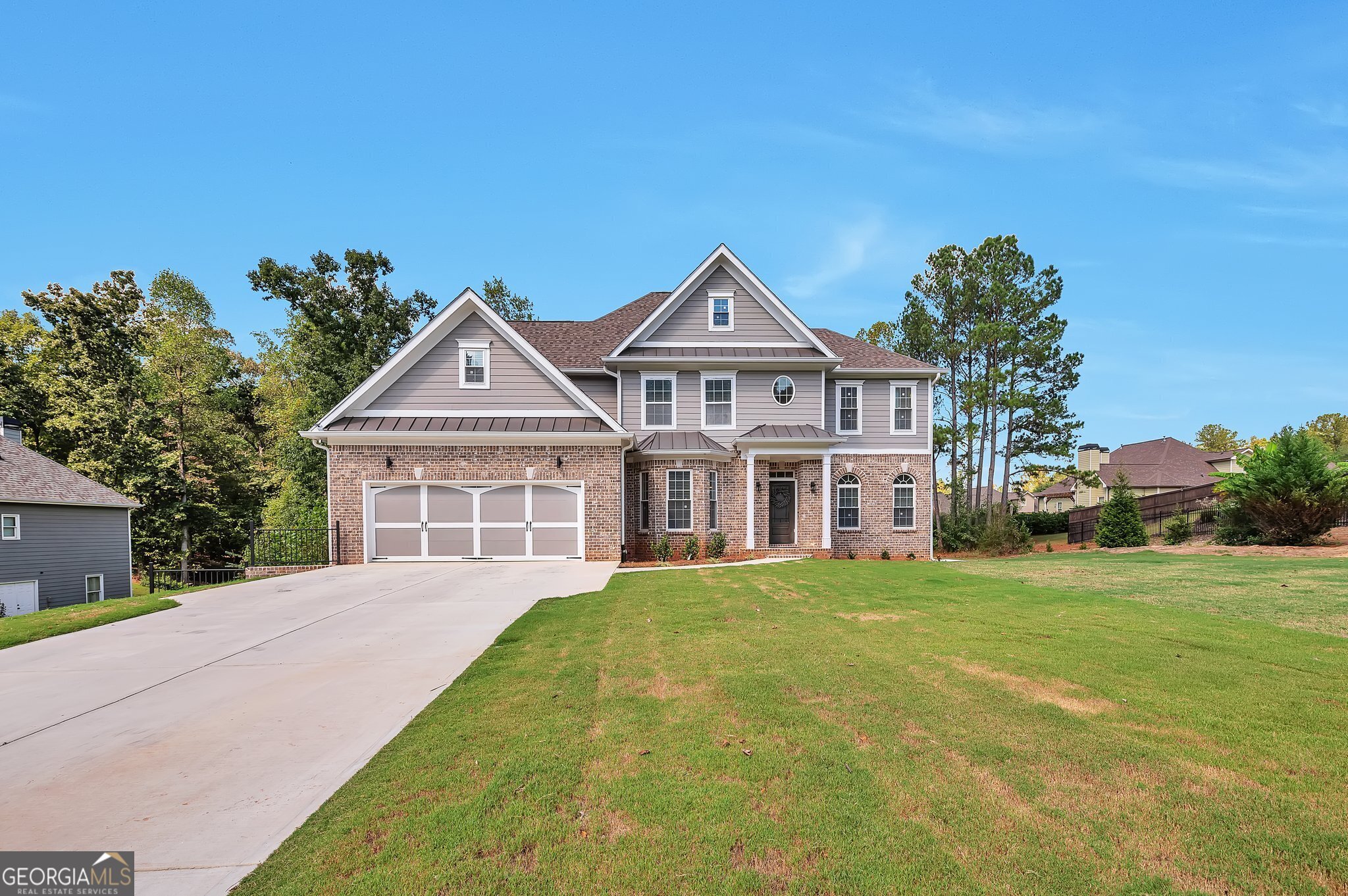 a front view of a house with a garden and yard