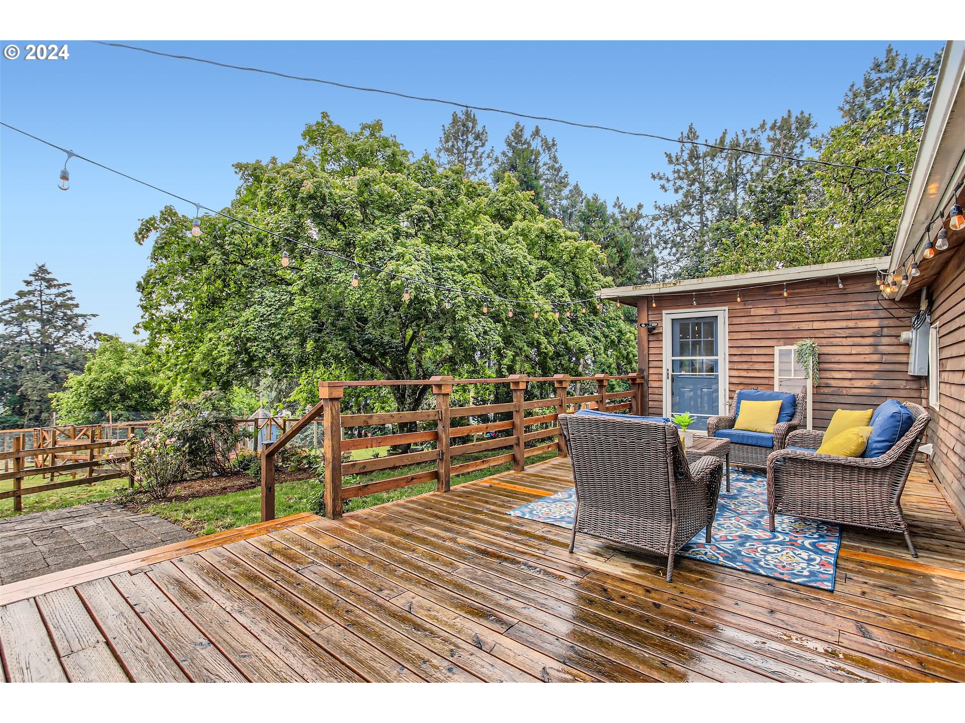 a roof deck with table and chairs and wooden floor