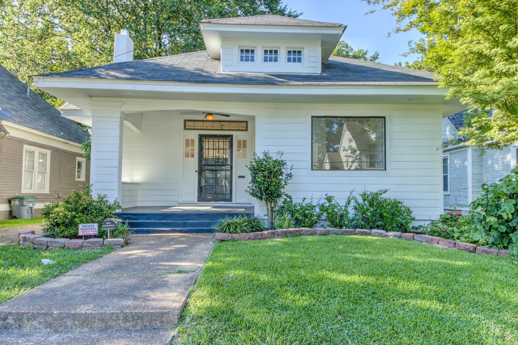 View of front of house with a front yard and covered porch