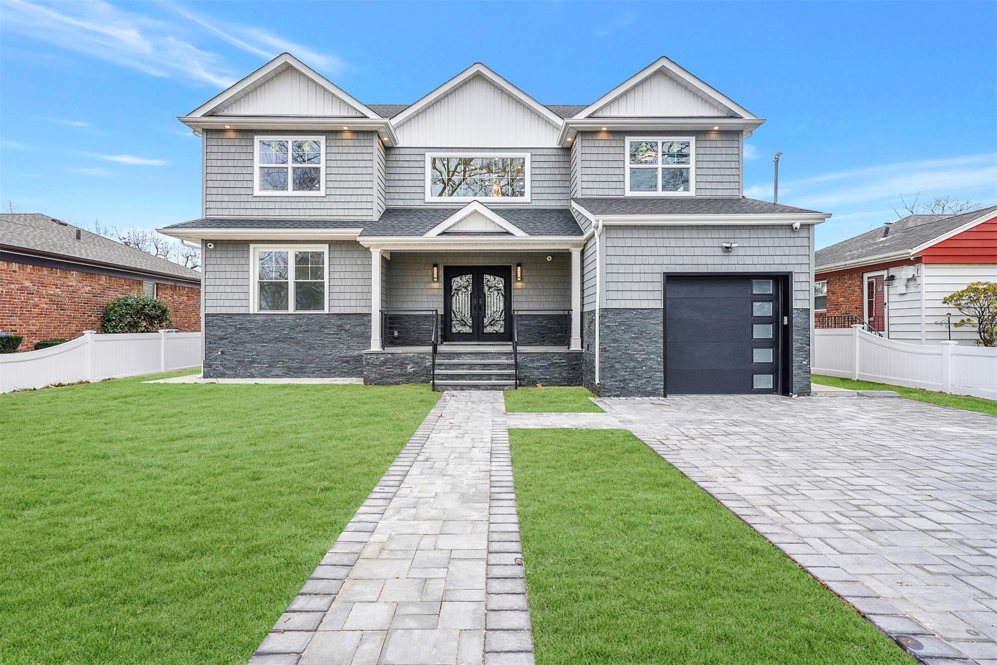 View of front of property with a front yard, french doors, and a garage