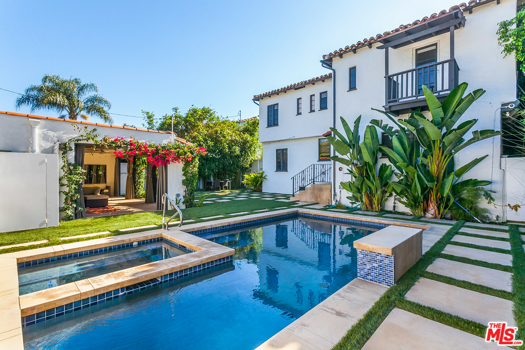 a view of a house with pool and sitting area