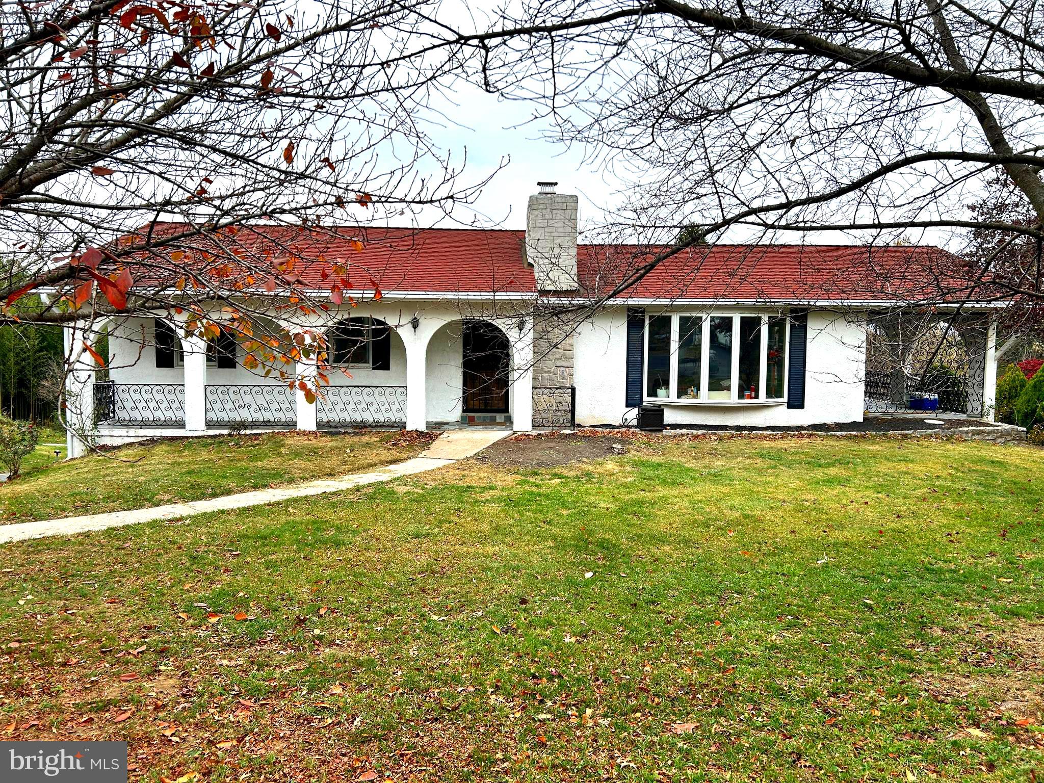 a view of a white house with a large tree