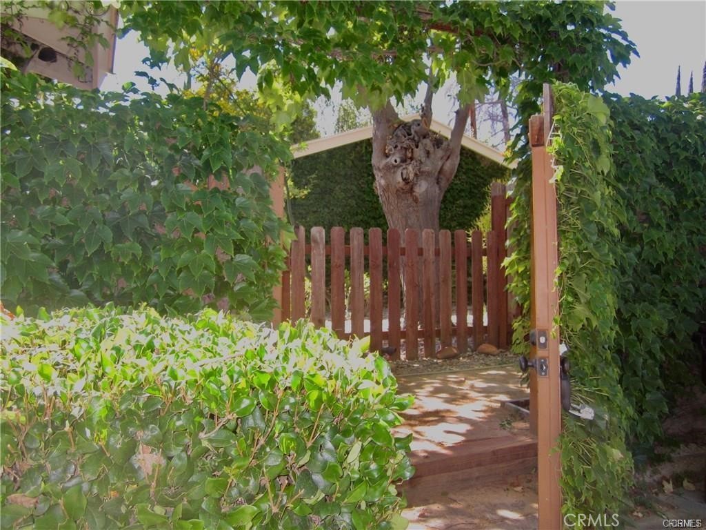 a view of a house with a tree and flower plants