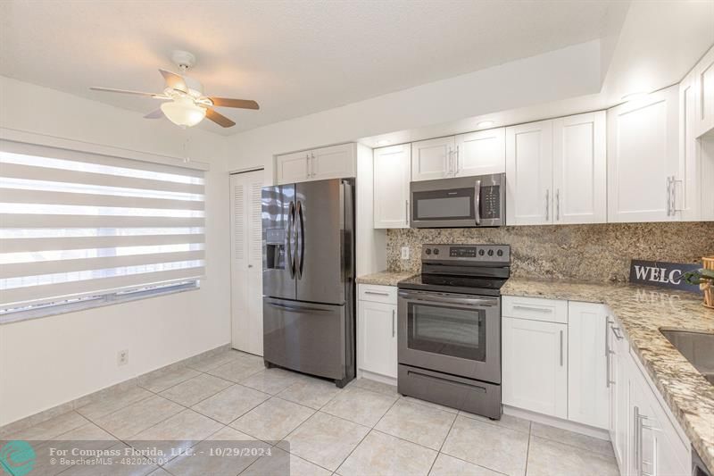 a kitchen with cabinets stainless steel appliances and a window