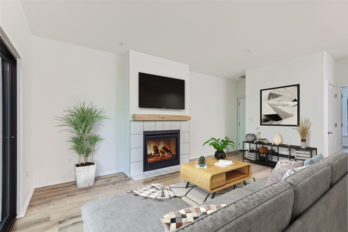 a living room with furniture a fireplace and a potted plant