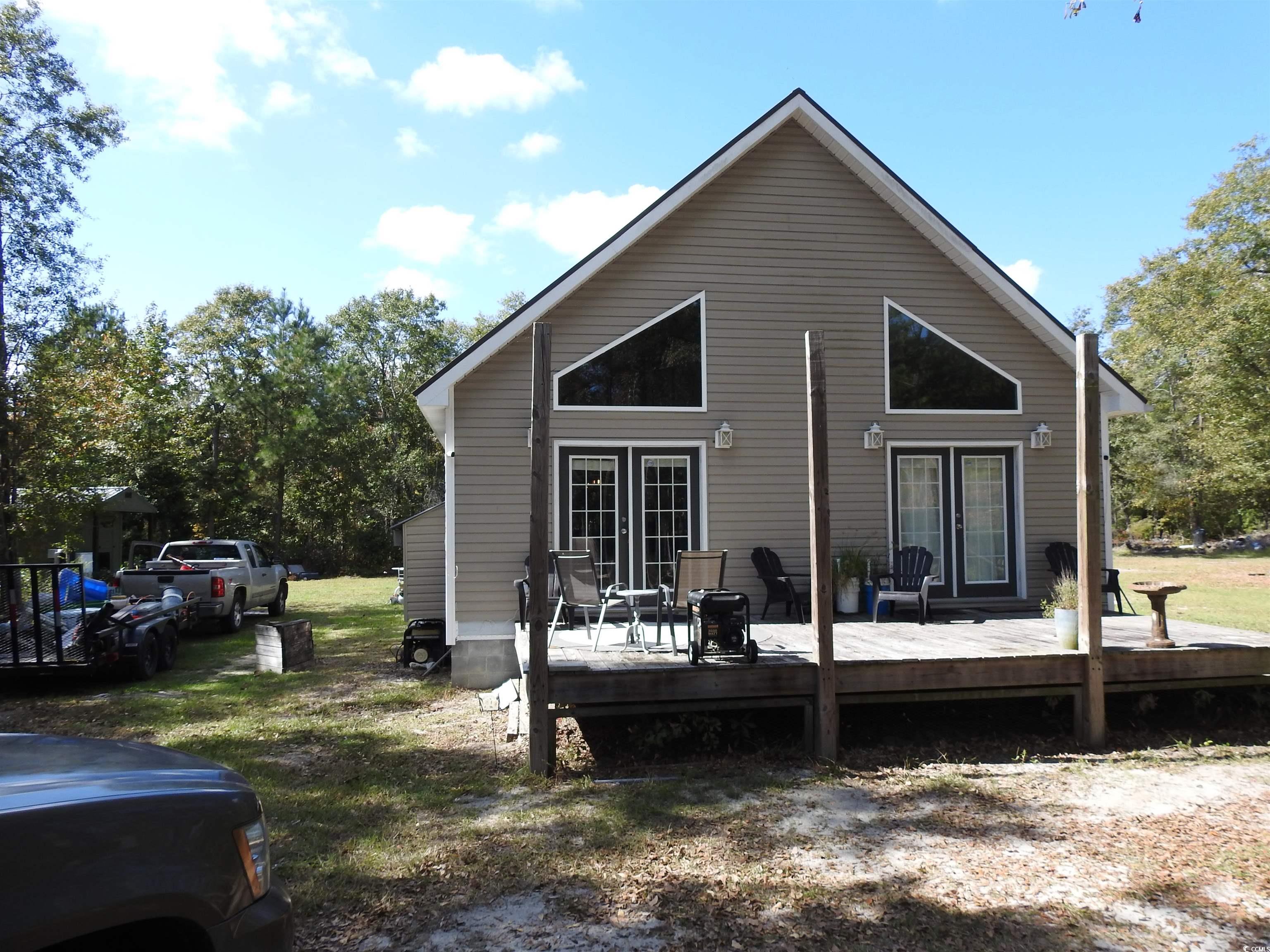 View of home's exterior featuring a lawn and a woo