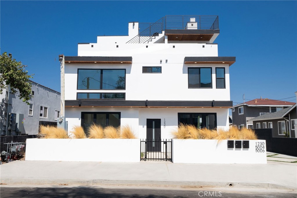 a view of a white building with swimming pool in front of it