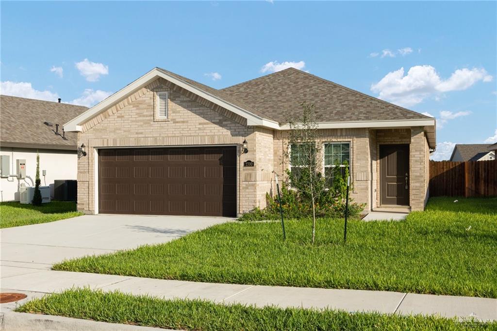 Ranch-style house with a front yard and a garage