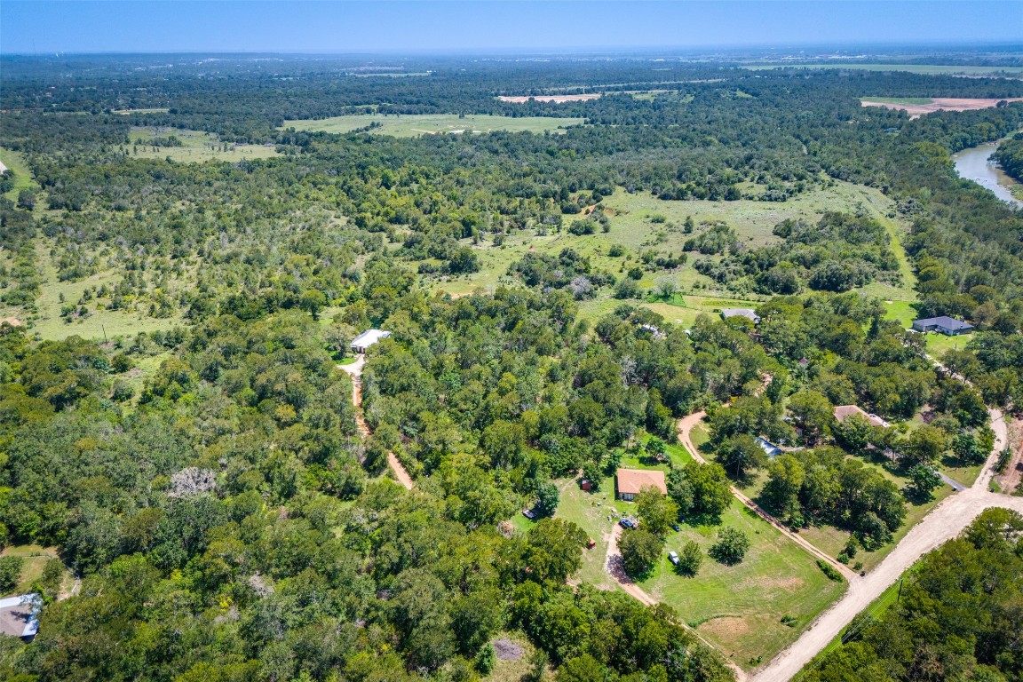 an aerial view of a houses with a yard and lake view