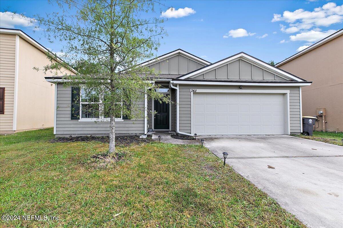 a front view of a house with a yard and garage