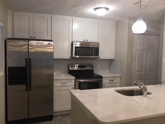 a kitchen with a refrigerator sink and stove