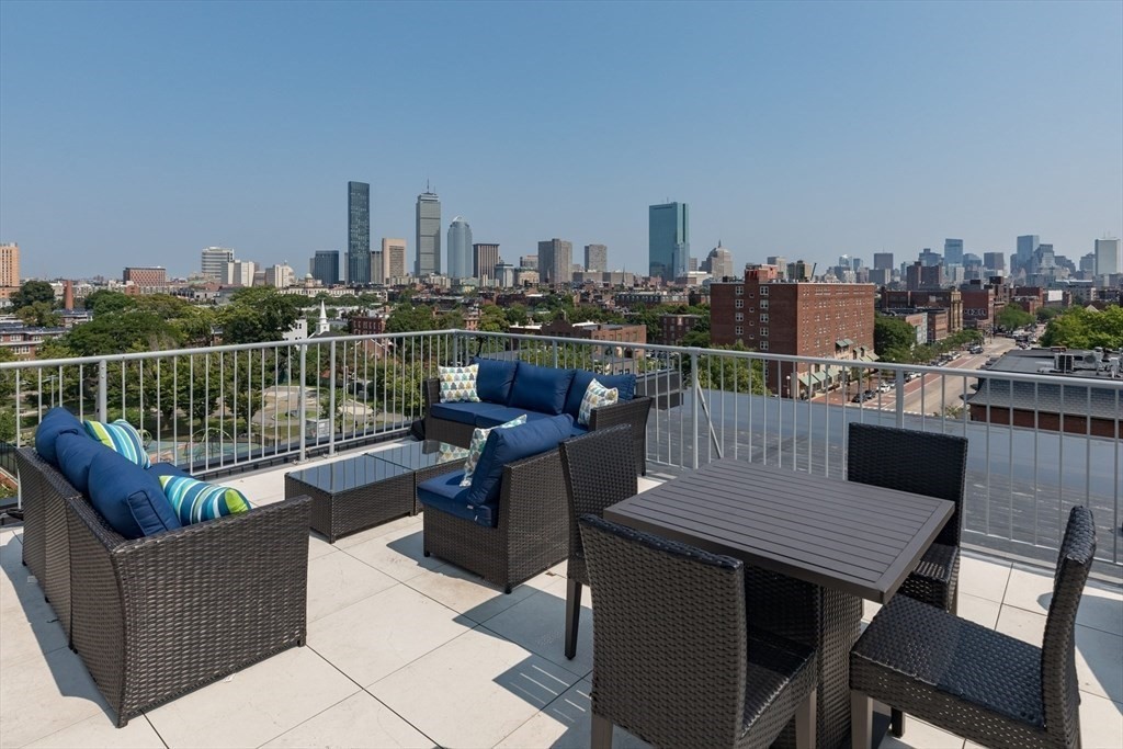 a view of a roof deck with furniture