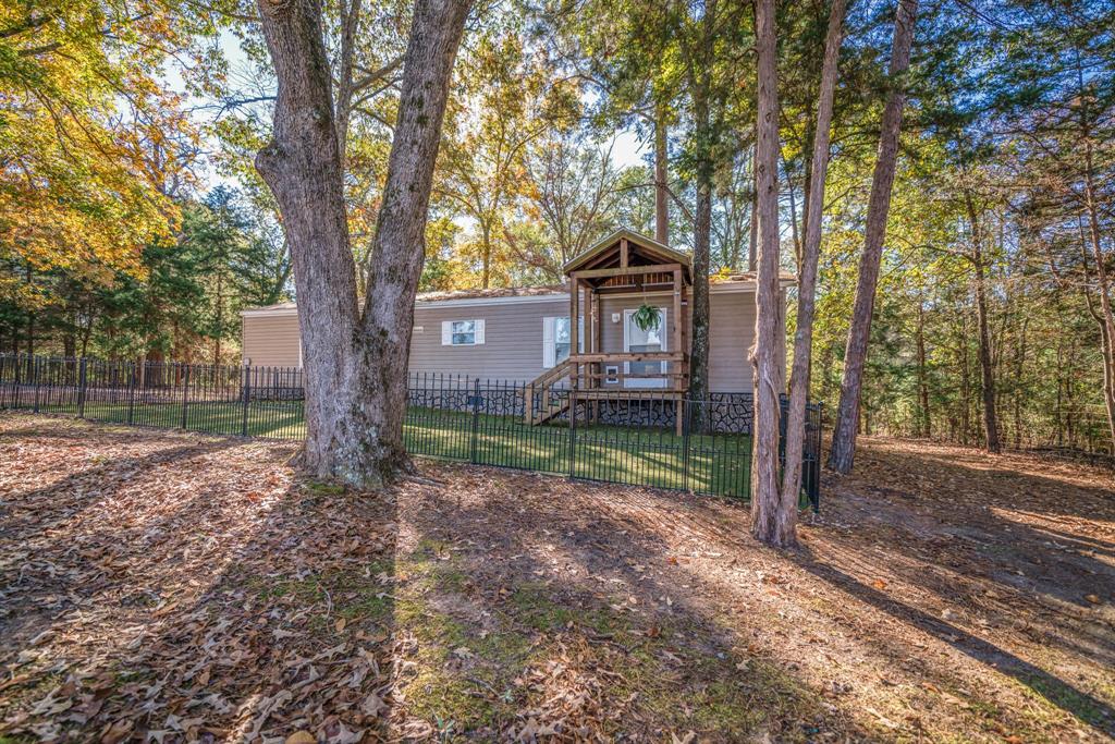 a view of a house with a yard and tree s