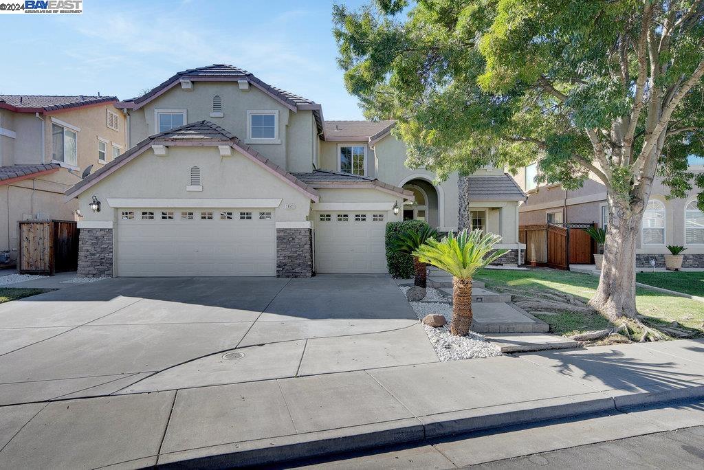 a front view of a house with a yard garage and outdoor seating