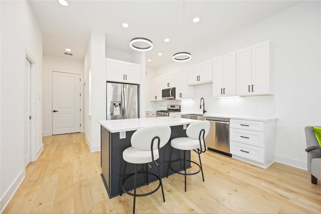 a kitchen with cabinets table and chairs