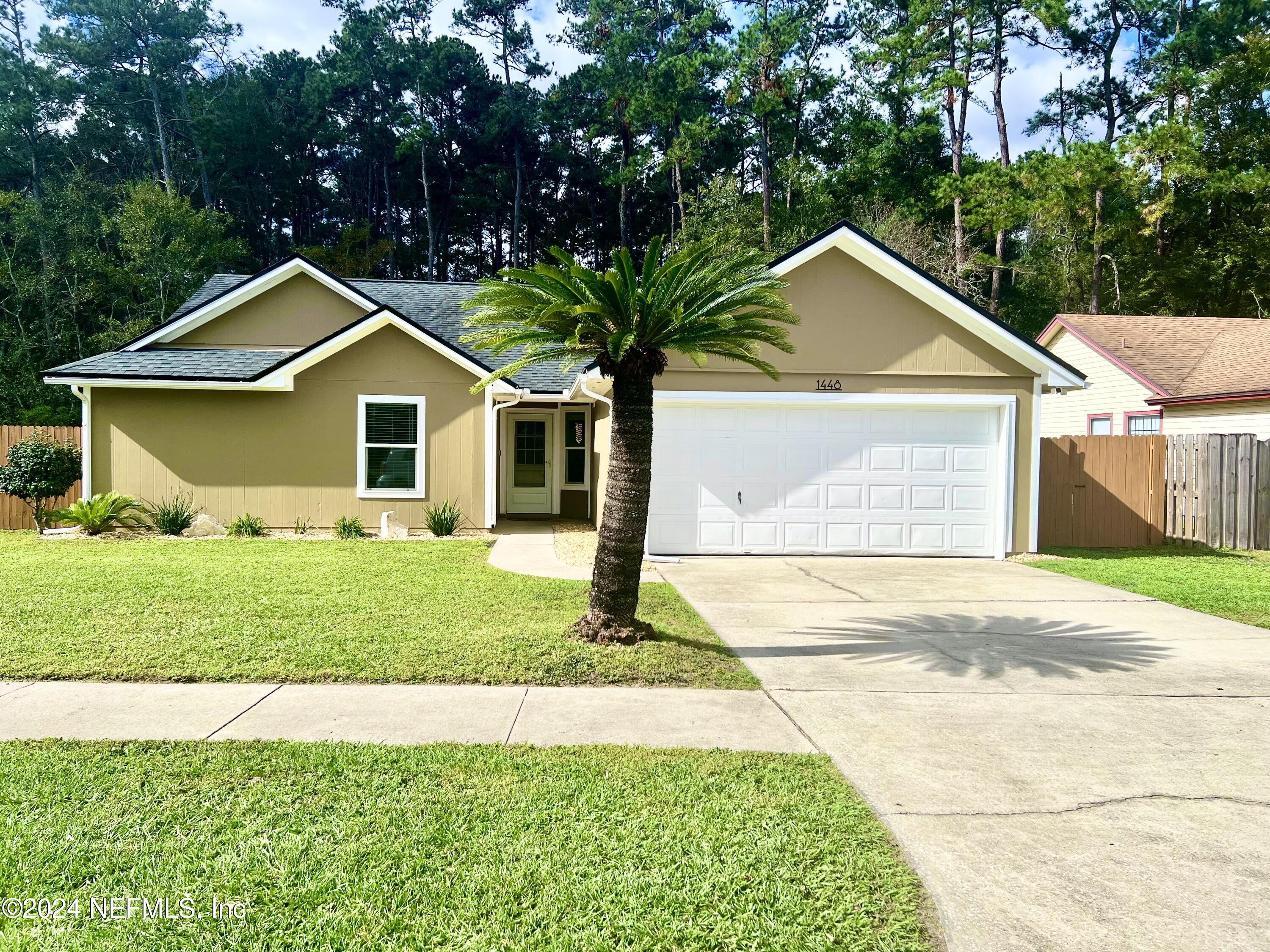 a front view of a house with a yard and garage