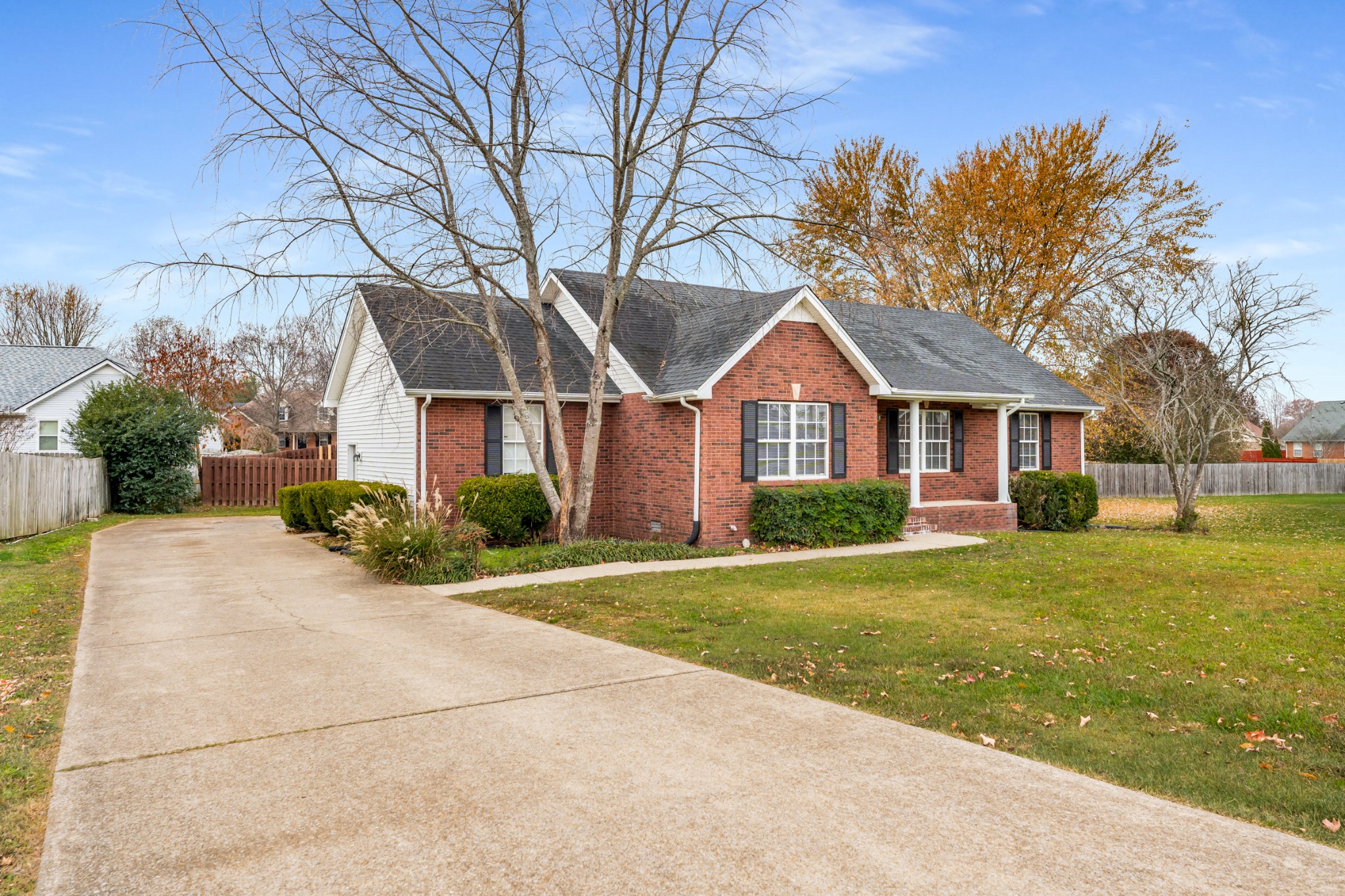 a front view of a house with a yard and trees