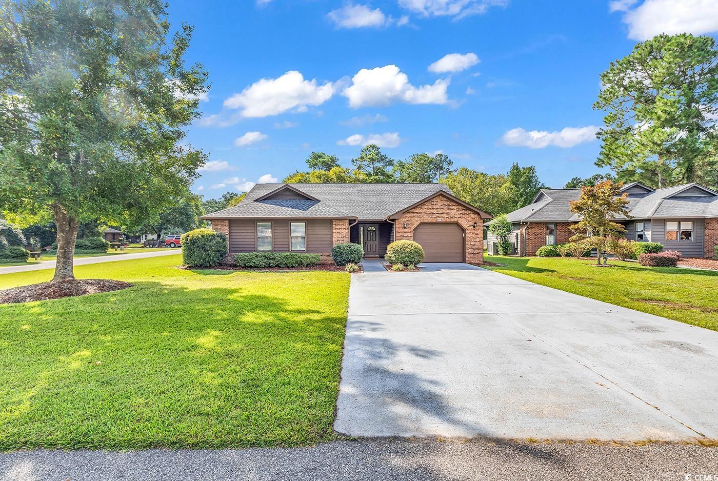 Ranch-style house with a garage and a front lawn