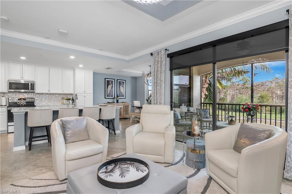 a living room with furniture and a large window with kitchen view