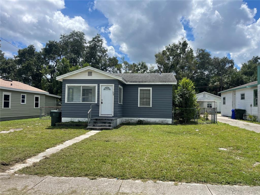 a view of a house with a yard and sitting area