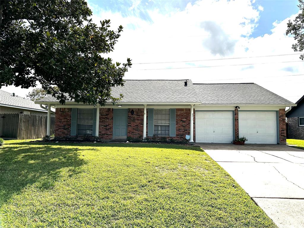 a front view of house with yard and trees in the background