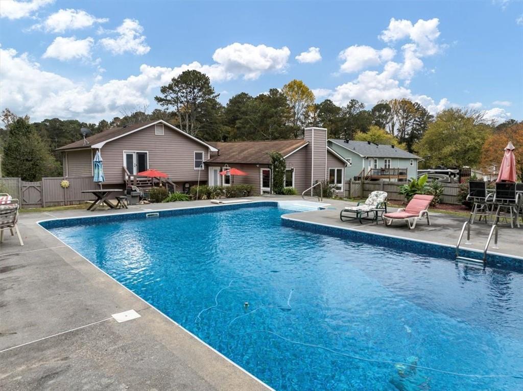 a view of a house with pool and chairs