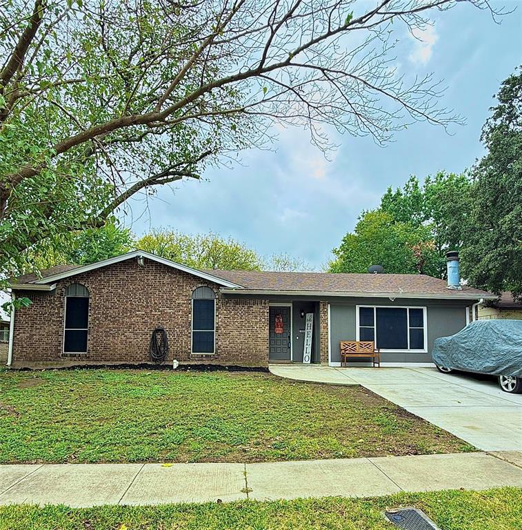 a view of a yard in front of a house with a large tree